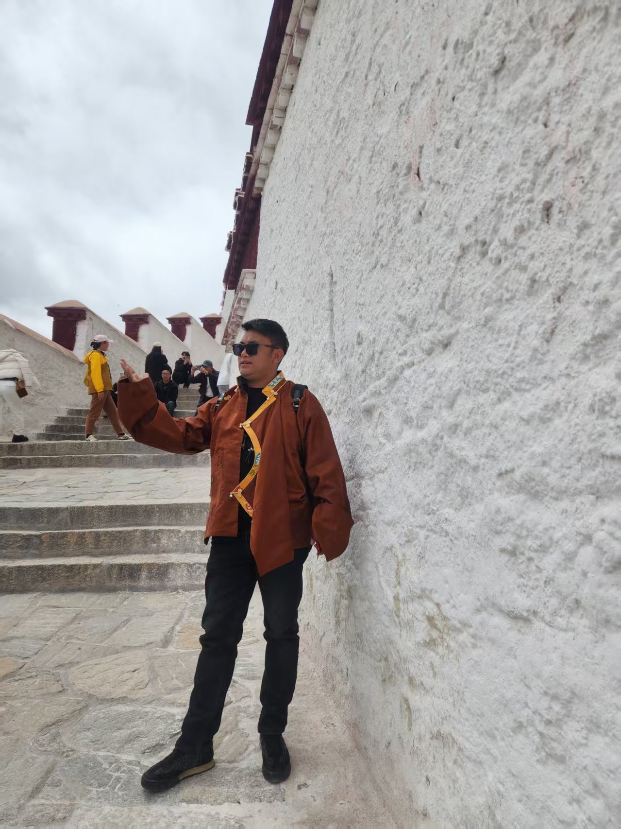Jimmy posing near a white monastery wall
